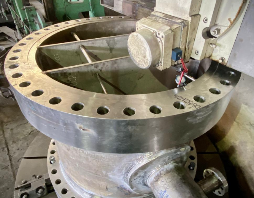 Rectificado a caras de bridas ya ensambladas de acero inoxidable en torno vertical de 3 metros de volteo. Peso total 8 TON